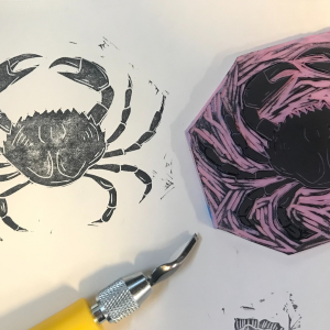 block print of crab alongside a carving tool